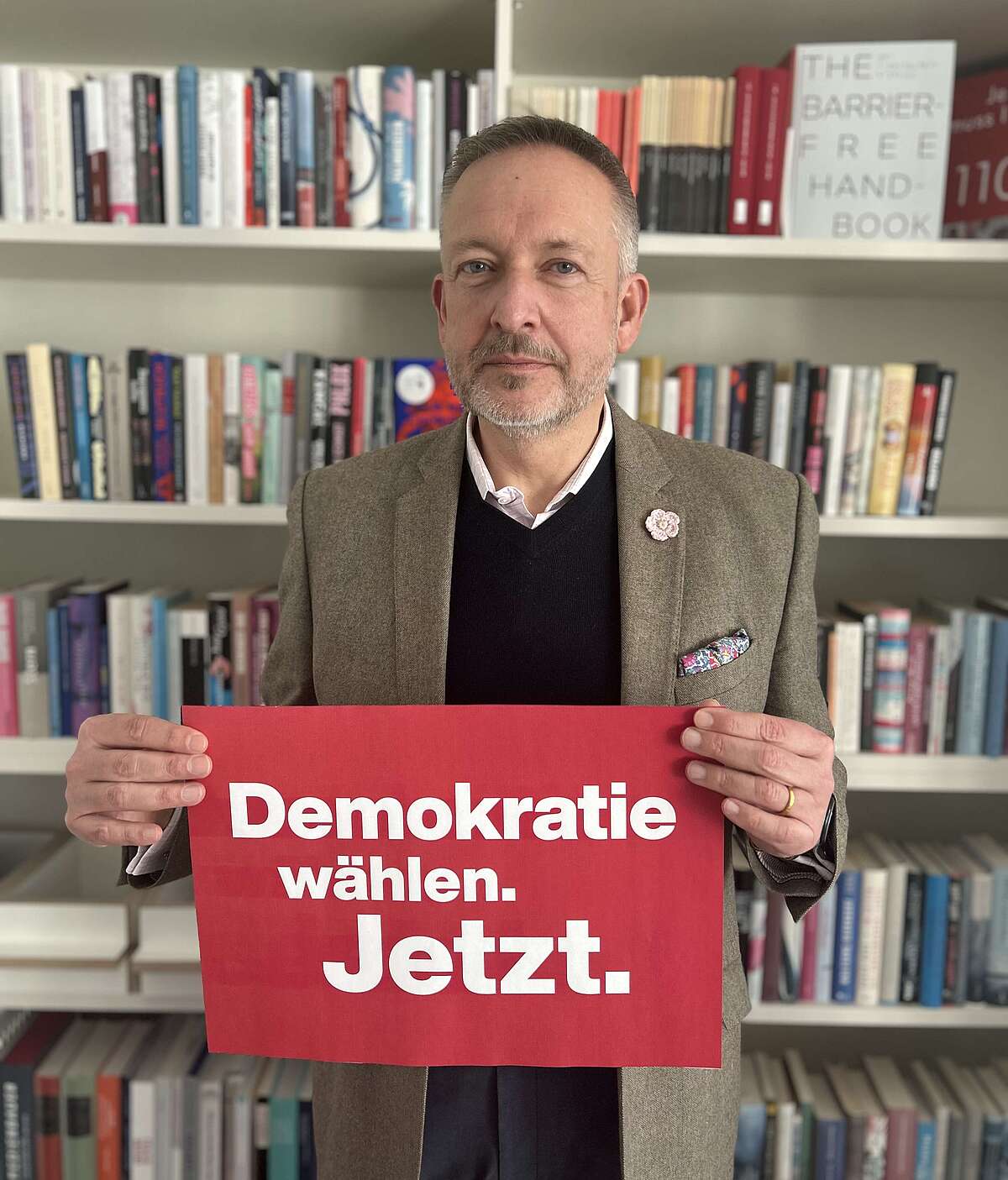 Hauptgeschäftsführer Peter Kraus vom Cleff hält ein Plakat in der Hand mit dem Schriftzug "Demokratie wählen. Jetzt."